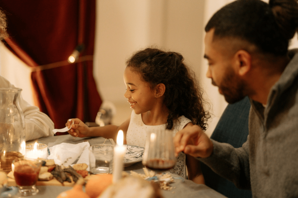 Papa memperhatikan anak perempuannya saat makan di meja makan