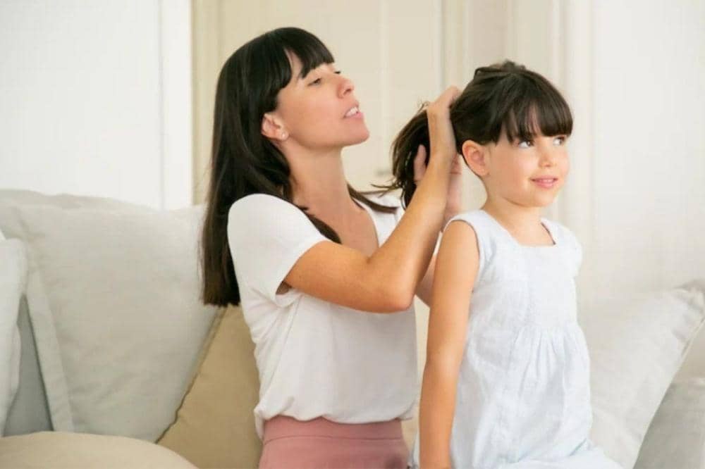 Mama menguncir rambut anak