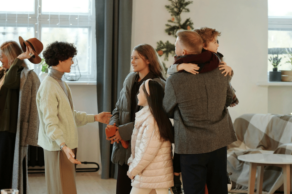 Sekumpulan keluarga yang terdiri dari tiga anak perempuan, papa, dan tante sedang berbincang di acara keluarga