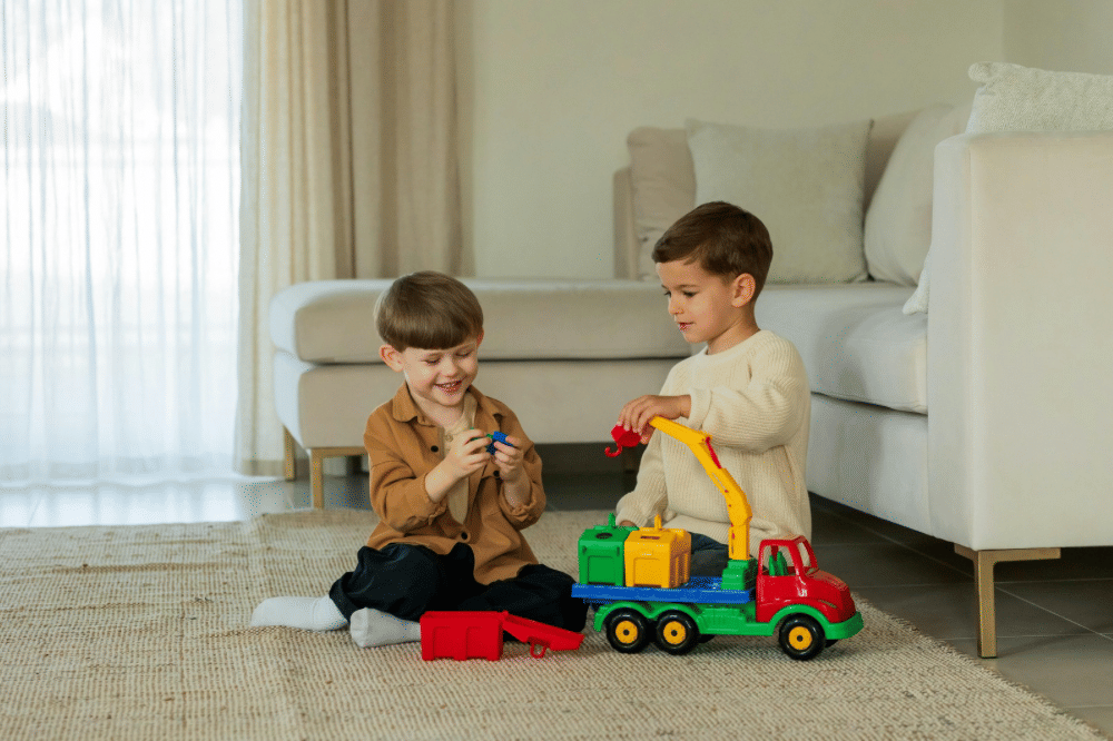 Dua anak laki-laki yang sedang bermain mobil mobilan