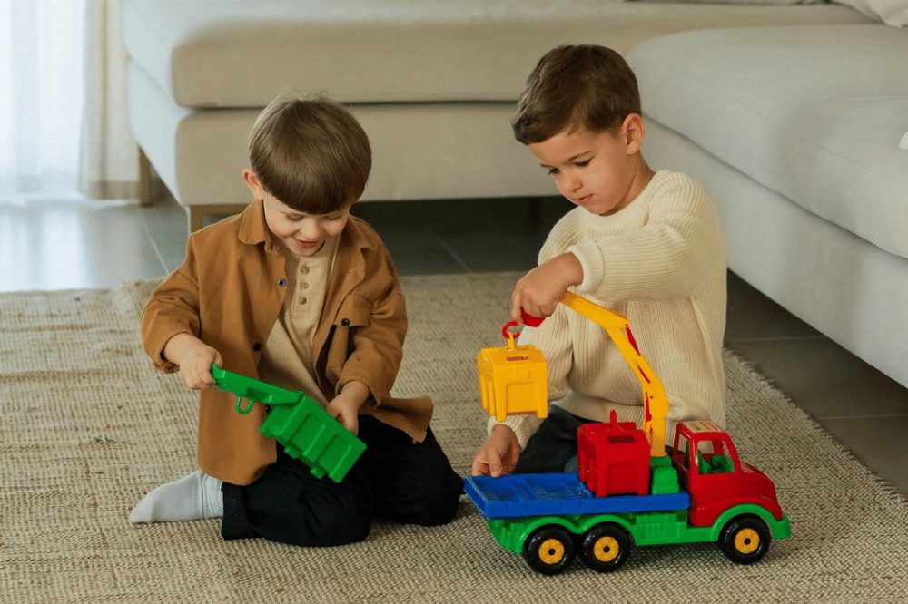 Dua anak laki-laki sedang bermain mobil-mobilan