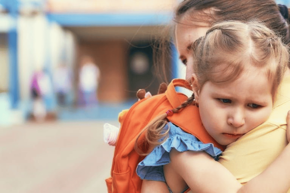Seorang anak perempuan yang memeluk ibunya setelah pulang sekolah