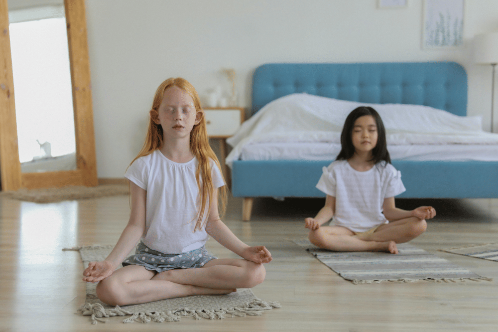 Dua anak perempuan sedang melakukan meditasi di kamar