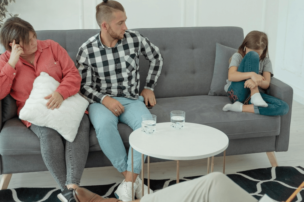 mama, papa, dan anak perempuannya terdiam di sofa 