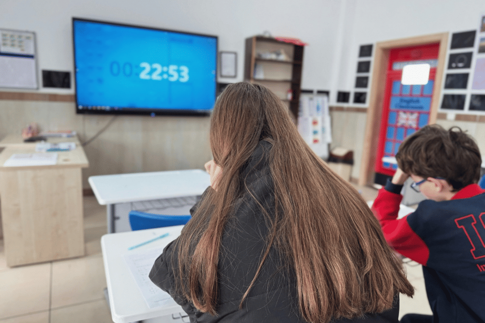 dua orang anak yang sedang mengerjakan soal di kelas