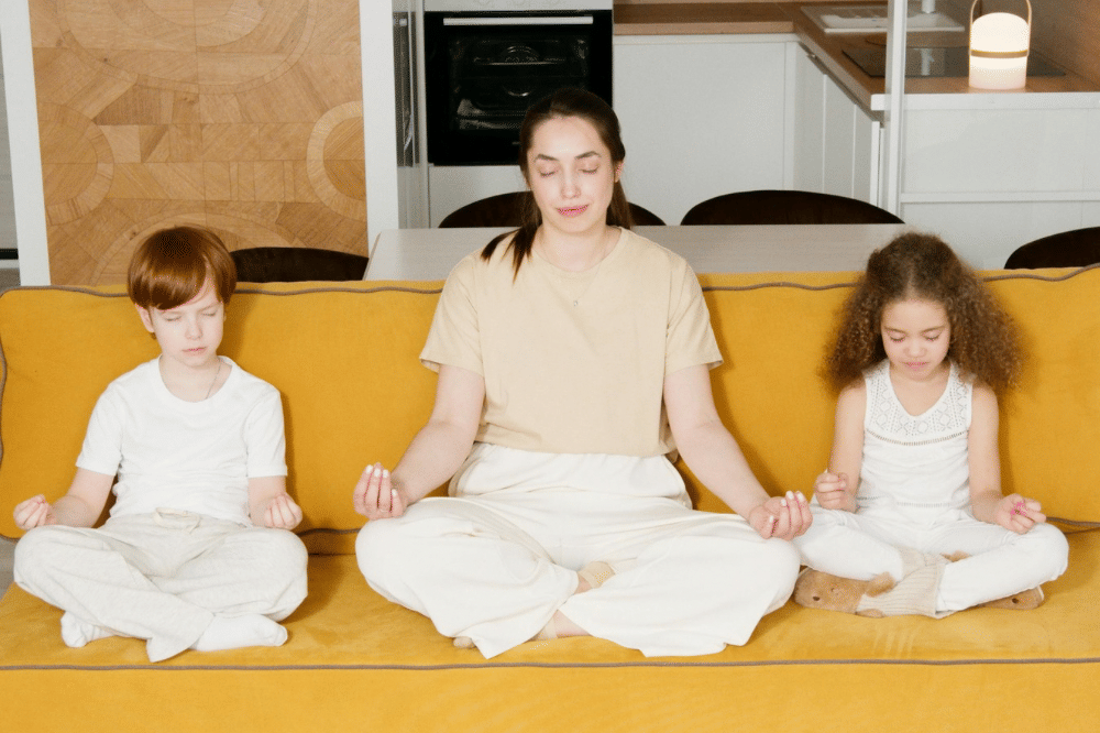 mama dana kedua anaknya sedang melakukan meditasi di atas sofa