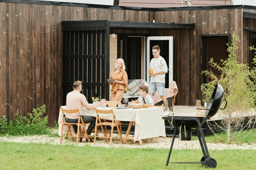 Papa, mama, dan kedua anak laki-lakinya menghabiskan waktu makan siang di halaman rumah 