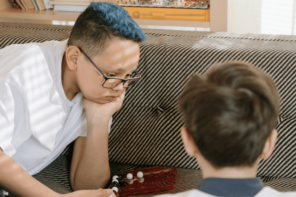 dua anak laki-laki yang sedang memperhatikan suatu objek