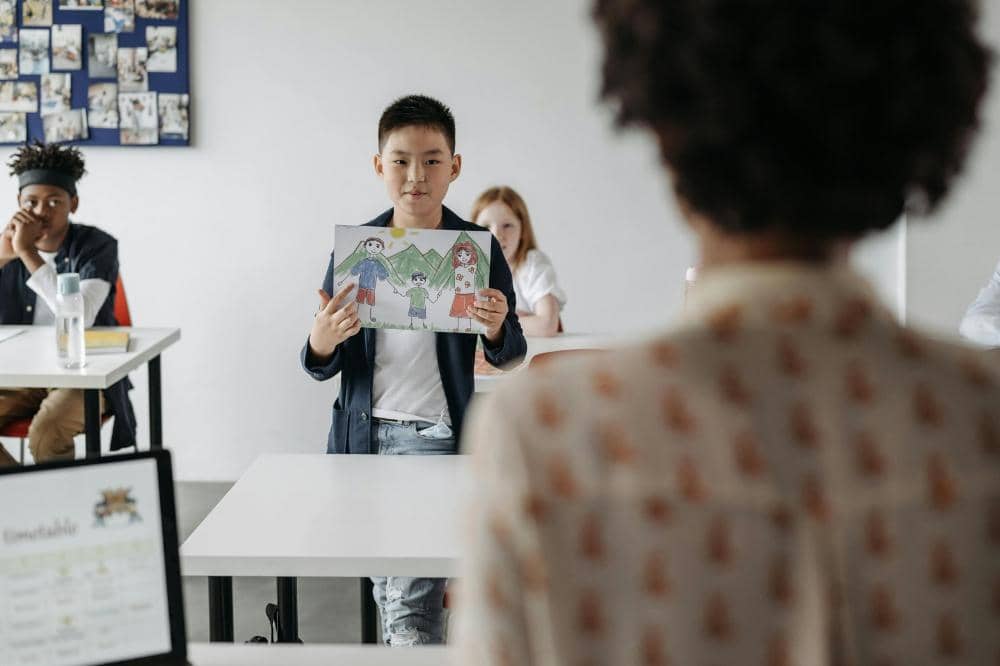 Anak menunjukkan gambarnya 