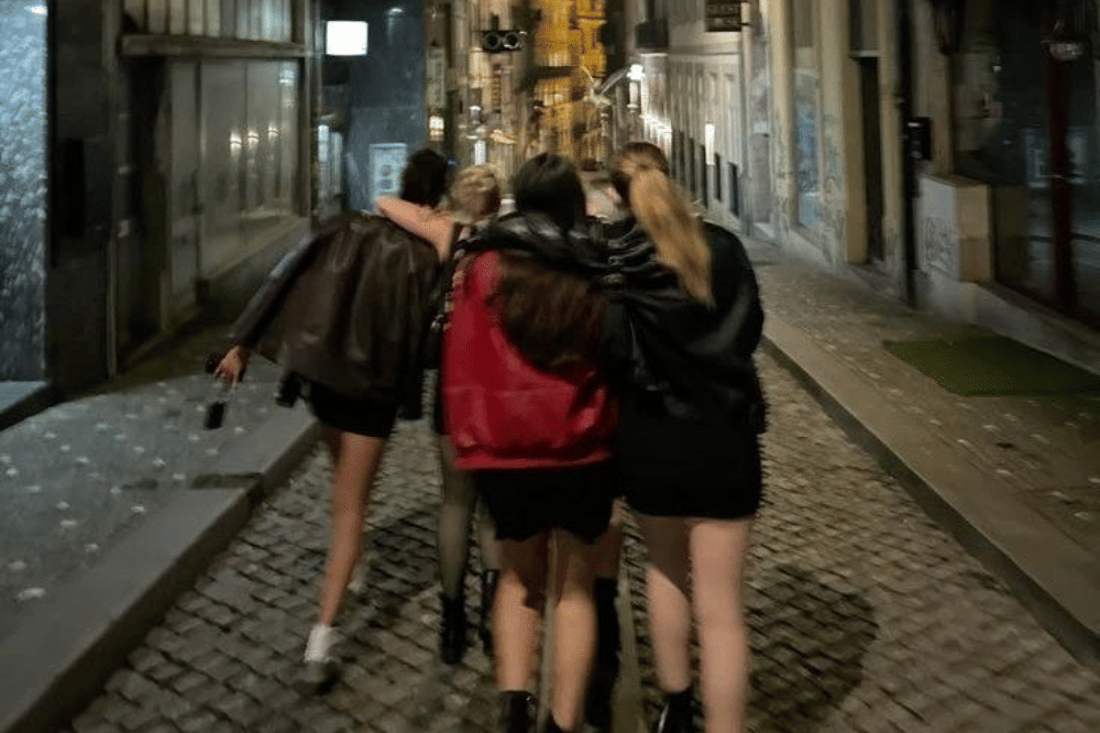 Sekelompok empat remaja berjalan bersama di jalan berbatu pada malam hari