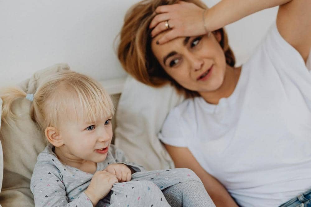 Mama berbaring di tempat tidur bersama anak