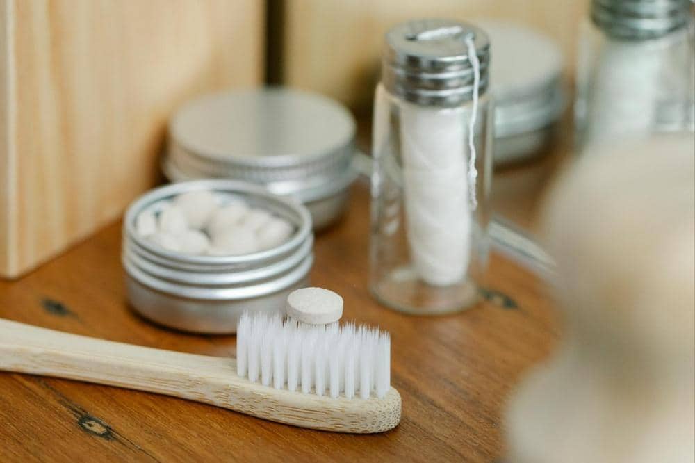 Sikat gigi bambu dengan tablet pasta gigi di atasnya