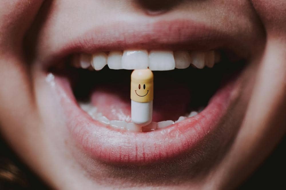 Mulut tersenyum memperlihatkan gigi putih dengan kapsul
