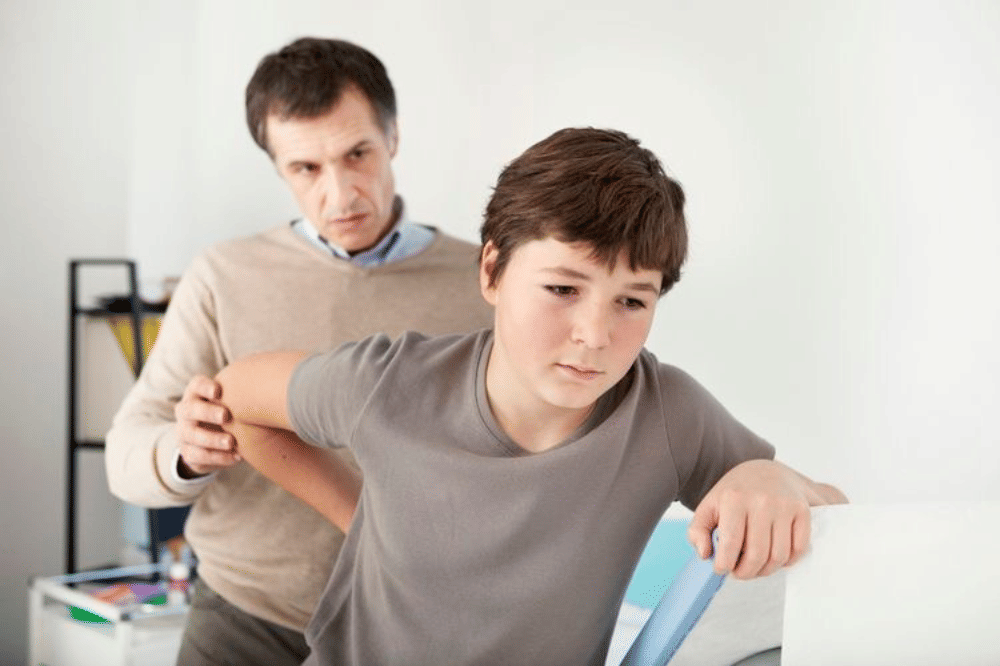 Seorang remaja laki-laki diperiksa oleh seorang terapis 