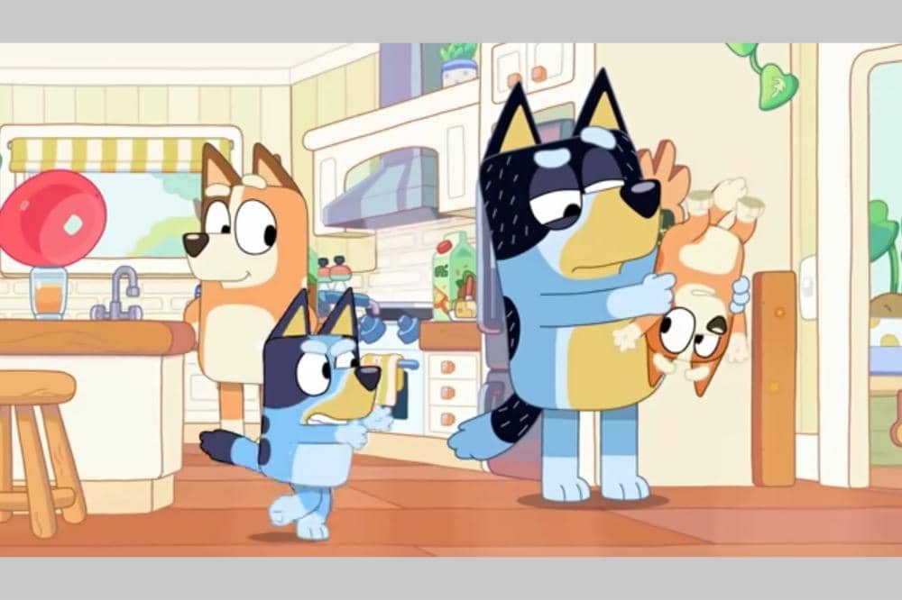 Keluara Bluey Heller sedang berinteraksi di dapur rumah dengan suasana ceria dan penuh warna.