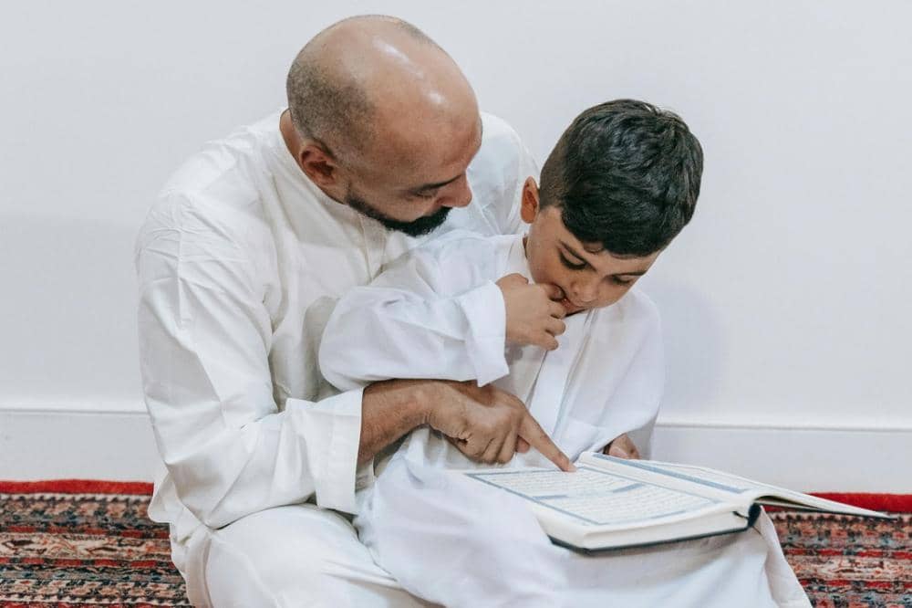 Papa mengajarkan anak membaca Al-Qur'an