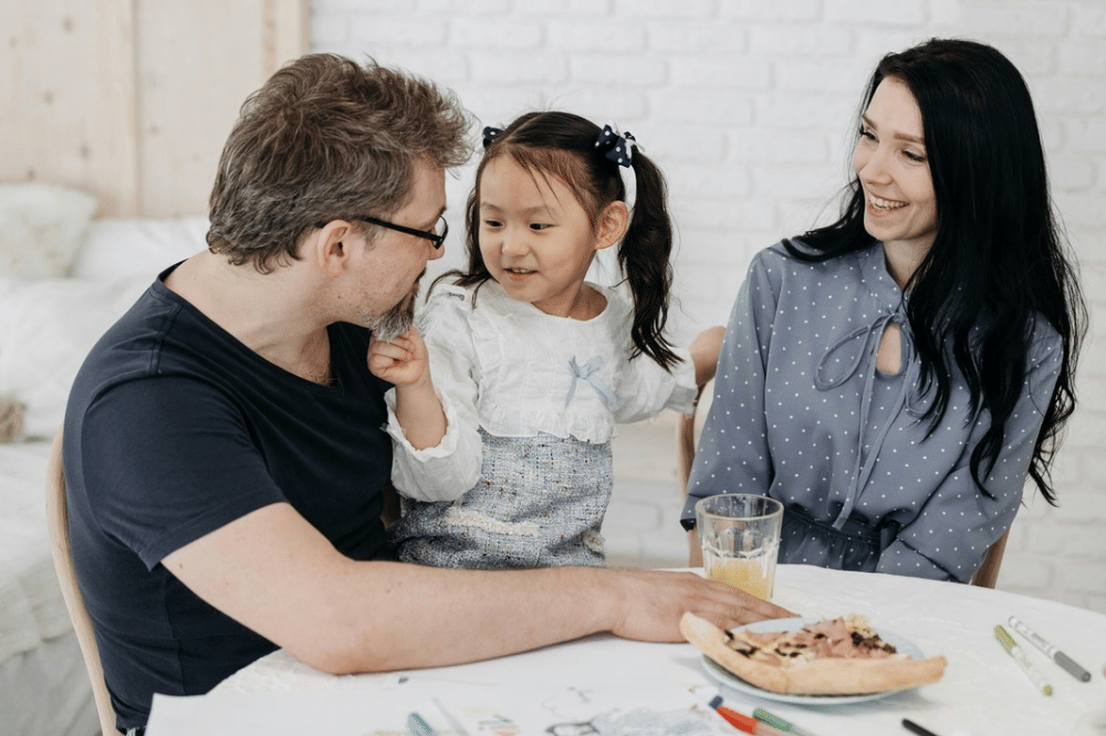 Tiga anggota keluarga, papa, anak, dan mama sedang berbincang
