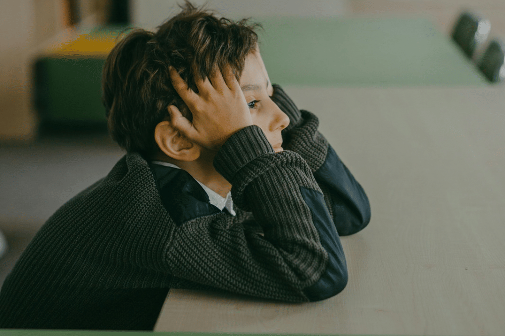 Seorang anak laki laki terlihat sedih 