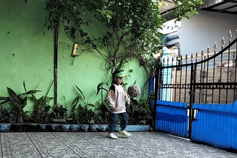 Zaki Abbas sedang bermain bola di halaman rumah