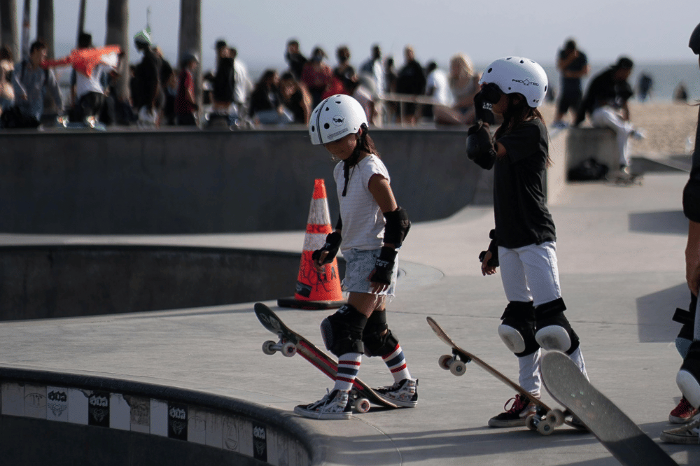 dua anak perempuan bermain skateboard 