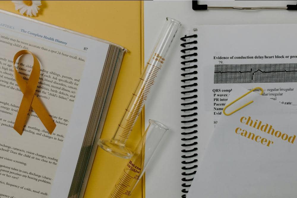 Pita kuning di atas buku medis, tabung reaksi, dan dokumen