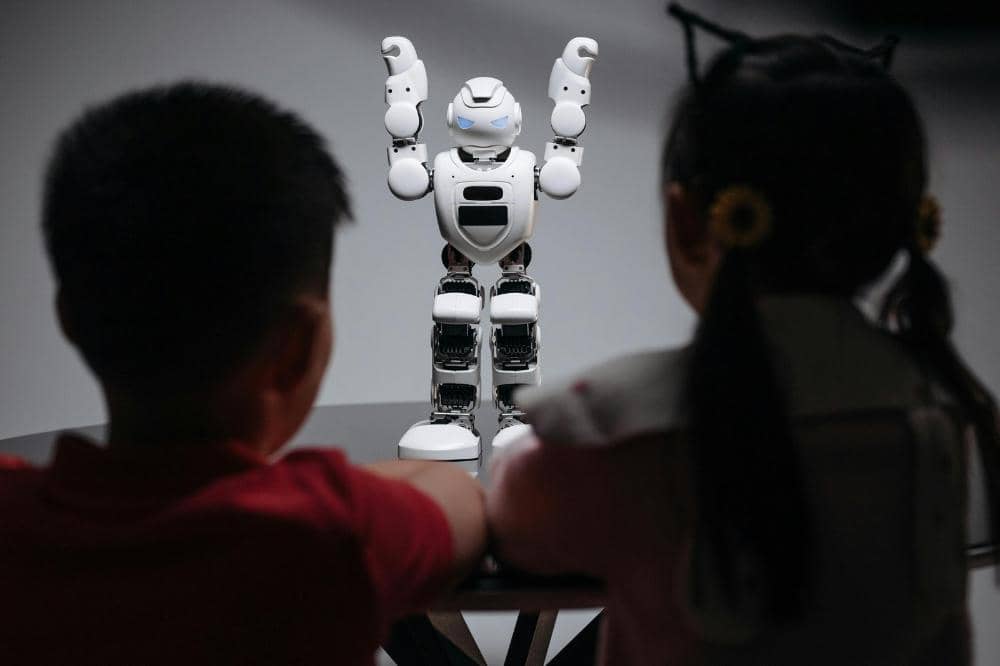 2 anak sedang melihat robot