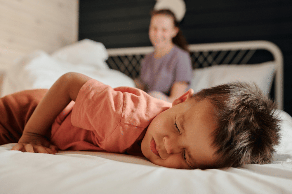 Anak laki-laki berbaring dan terlihat kesakitan 