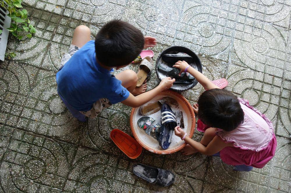 2 anak sedang mencuci sepatu