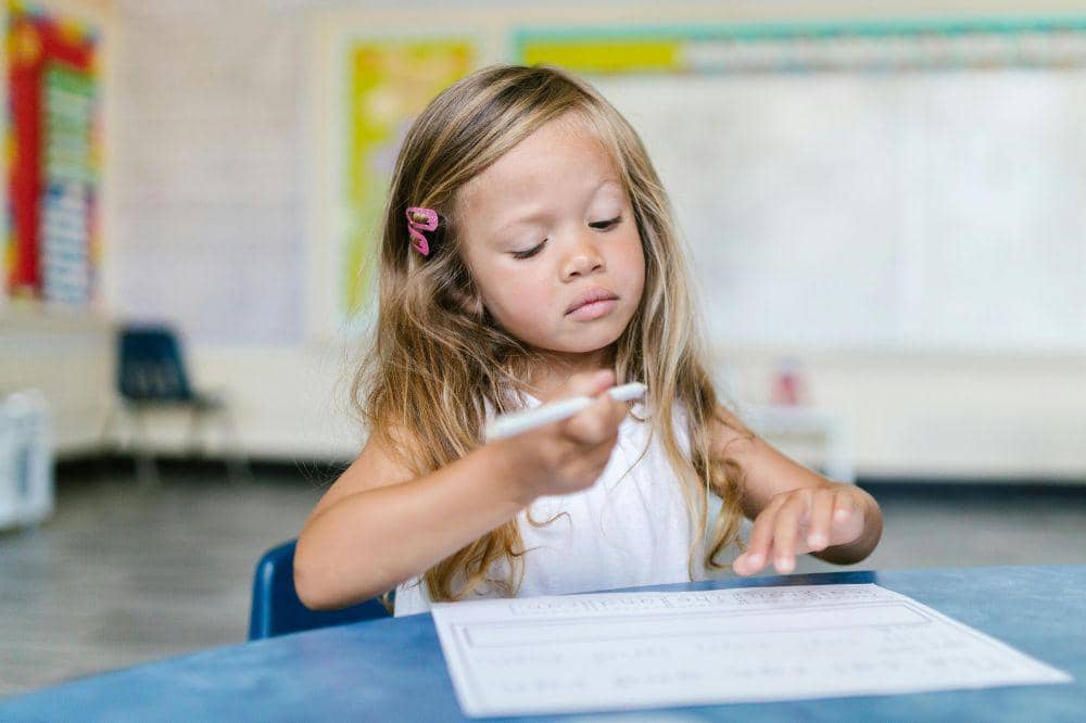 Anak perempuan saat belajar menulis