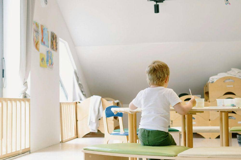 Anak sedang duduk dan belajar menulis