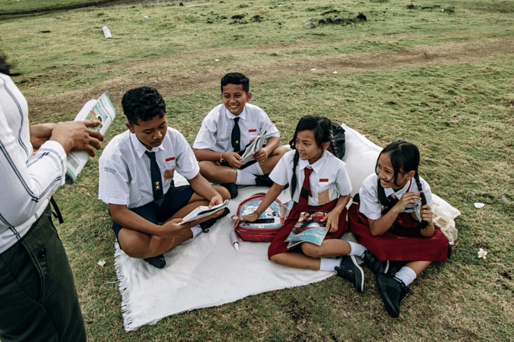 Murid-murid belajar bersama di luar ruangan 