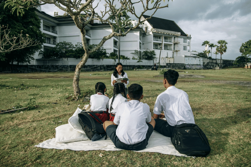 Guru dan murid belajar bersama di luar ruangan 