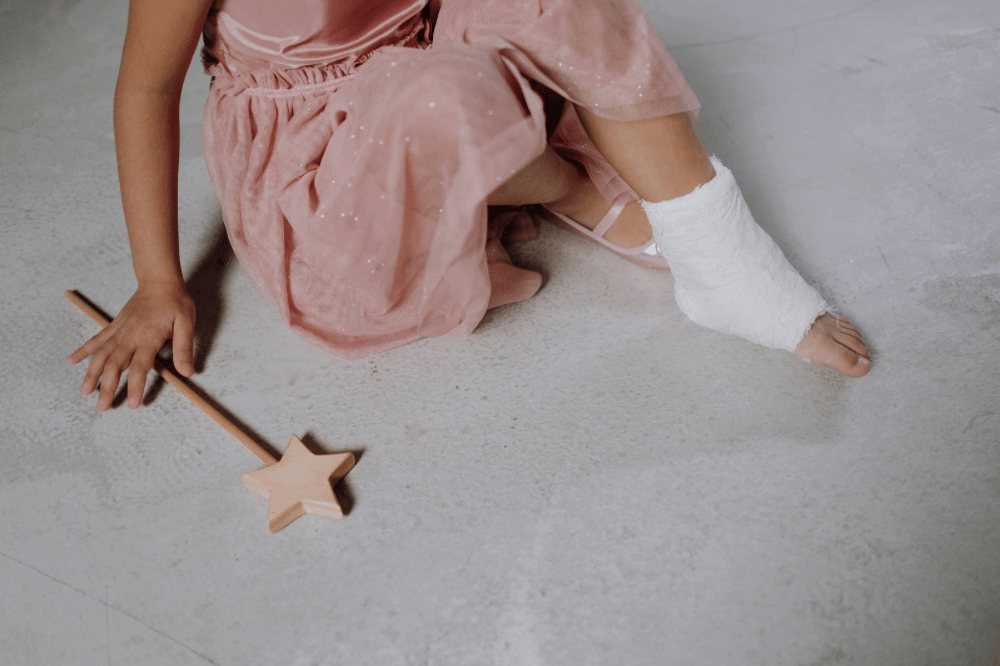 Anak anak perempuan duduk di lantai dengan kaki kanan dibalut perban 