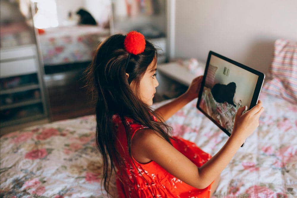 Anak bermain tablet di kamar