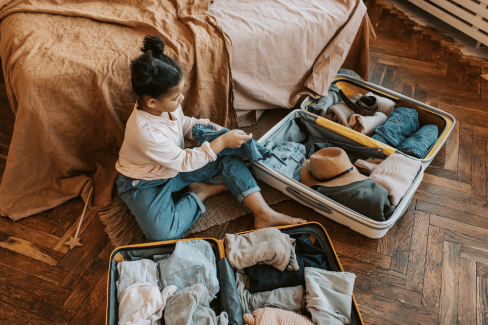 Seorang anak perempuan sedang packing baju 