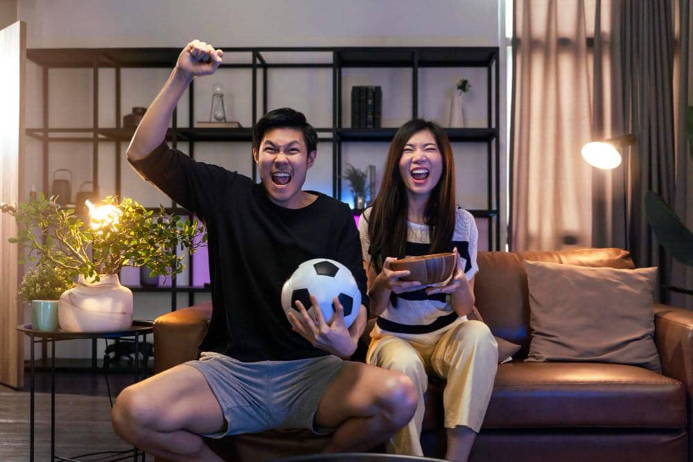 ilustrasi pasangan menonton bola di rumah