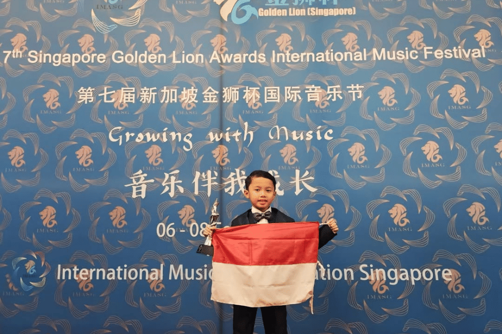 Prama berpose sambil mengibarkan bendera Indonesia
