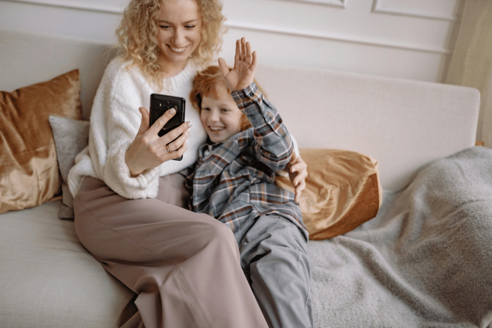 mama sedang bermain handphone dengan anaknya