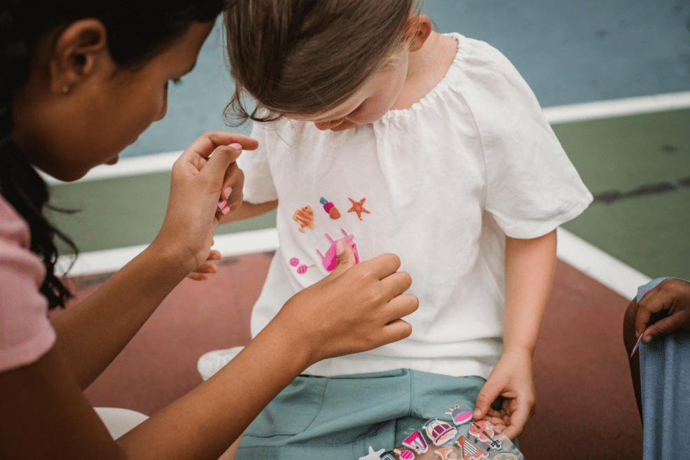 Dua anak perempuan bermain dengan sticker 