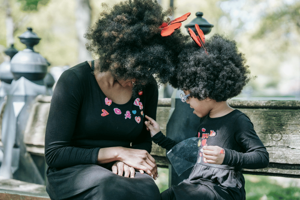 Seorang anak perempuan menempelkan sticker di baju sang mama