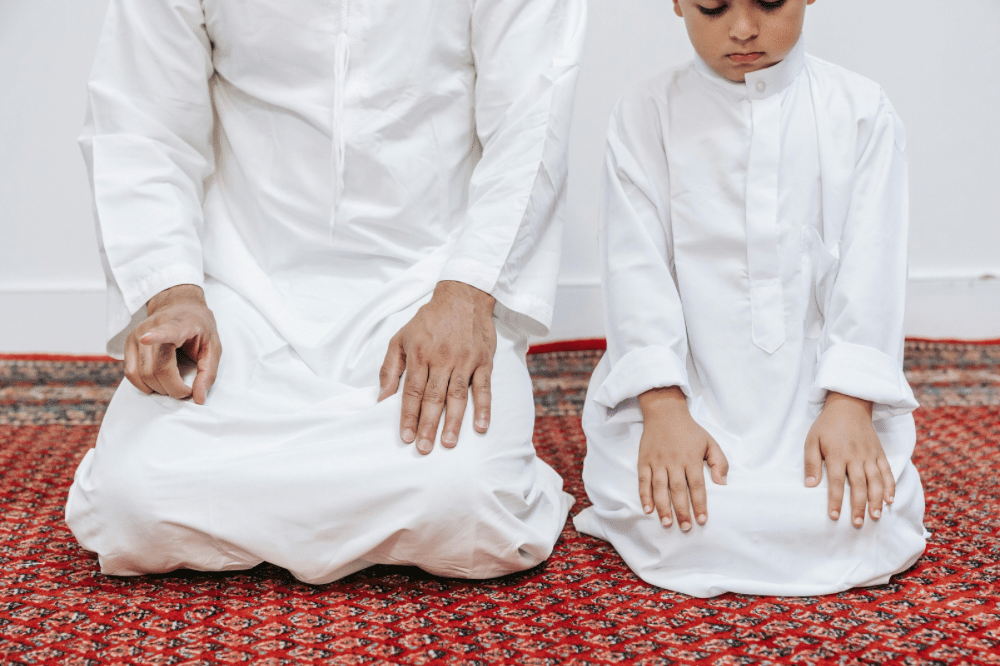 Papa dan sang anak sedang beribadah bersama
