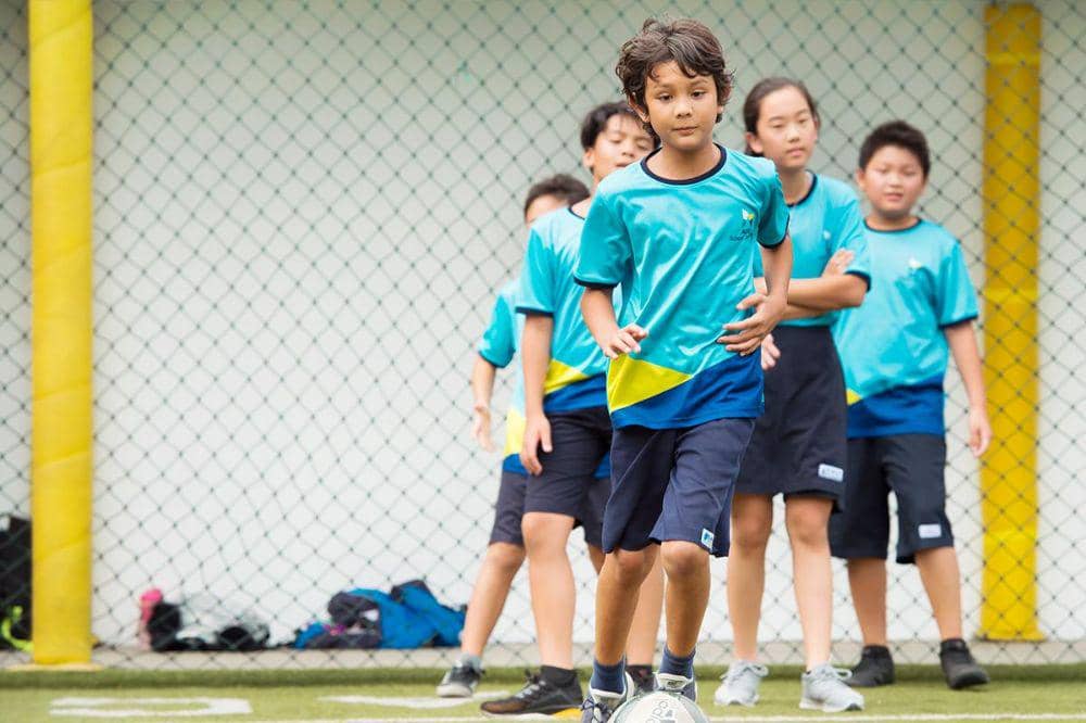 Siswa ACG School Jakarta sedang bermain bola di lapangan