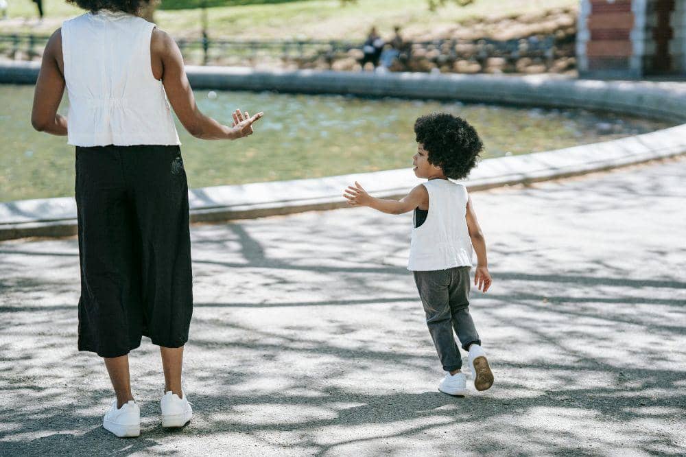 Mama mengawasi anak bermain di taman