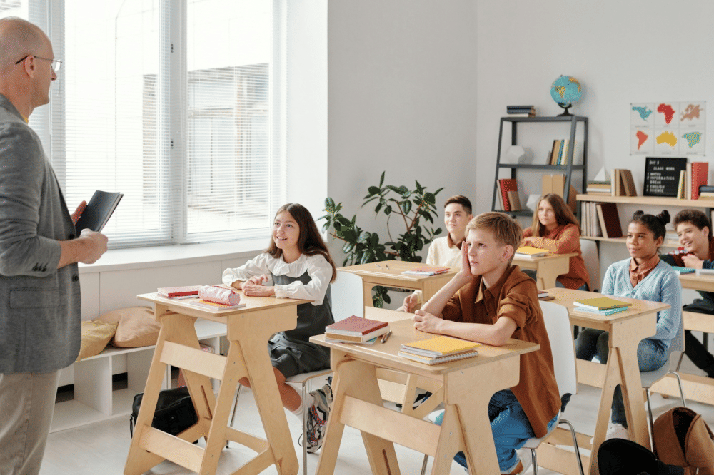 para murid mendengarkan gurunya di kelas