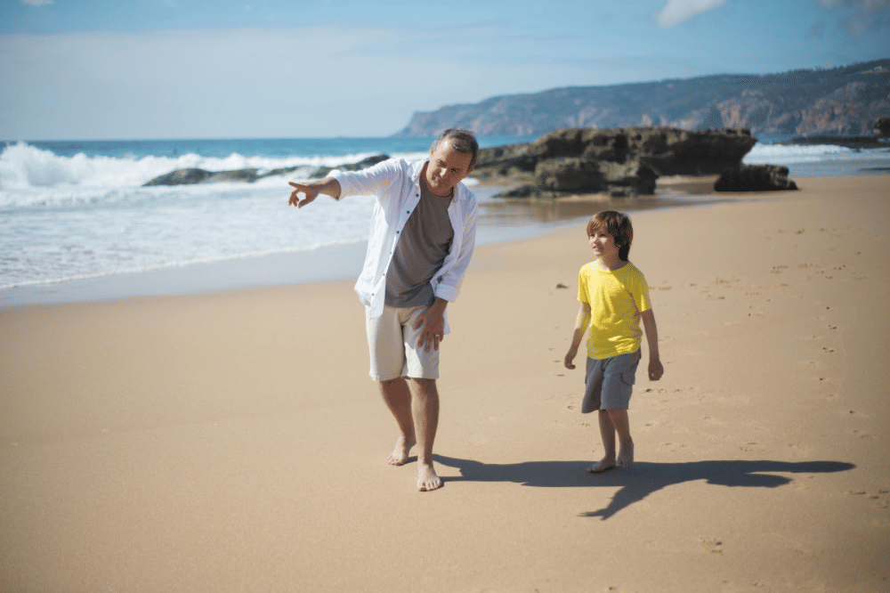 Papa dan sang anak sedang bermain di pantai