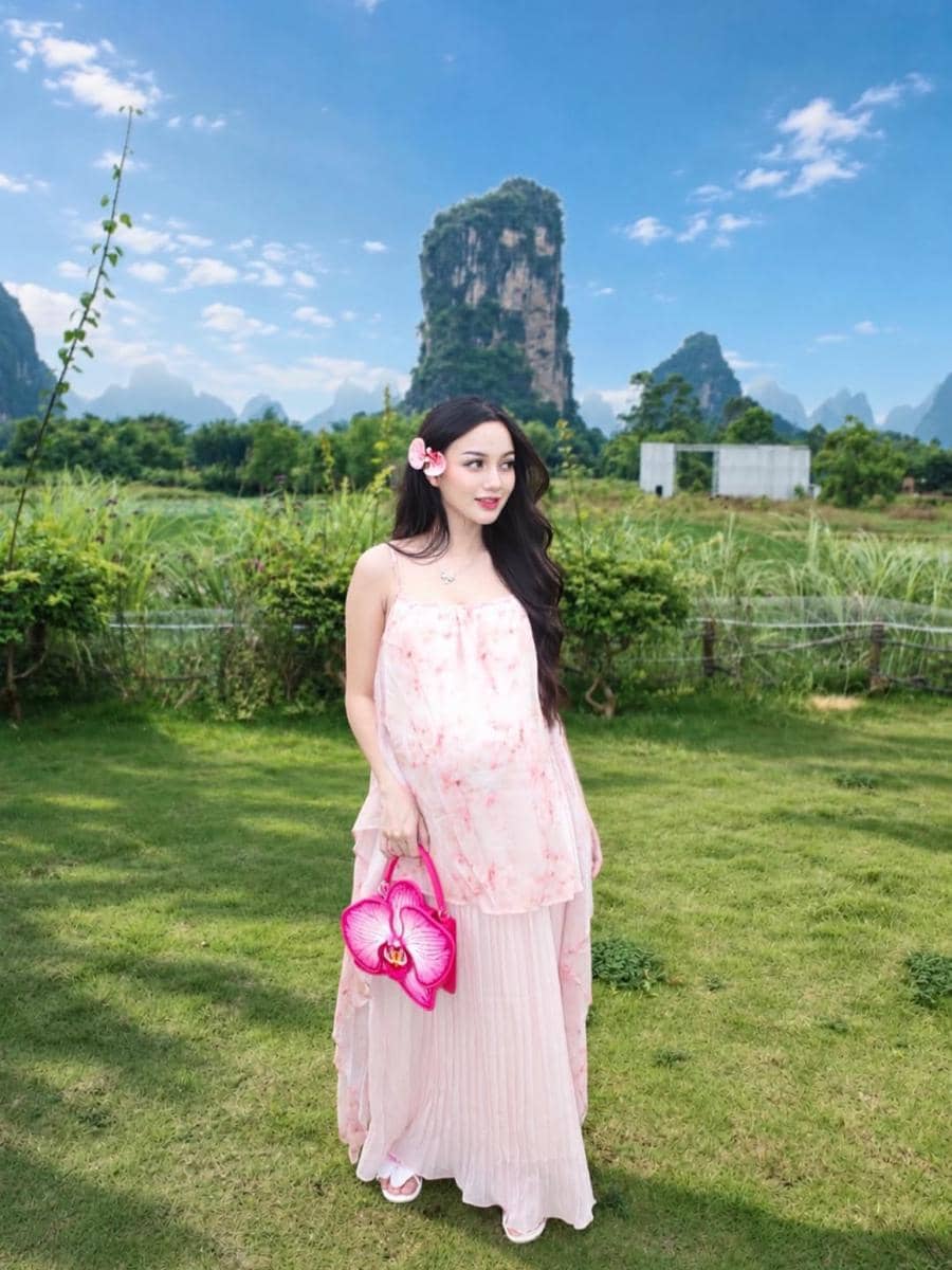 pakai gaun pink dengan tas bunga anggrek