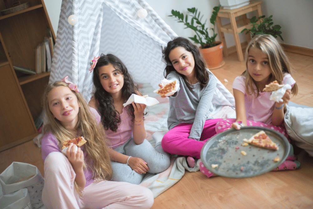 Anak anak sedang makan pizza bersama