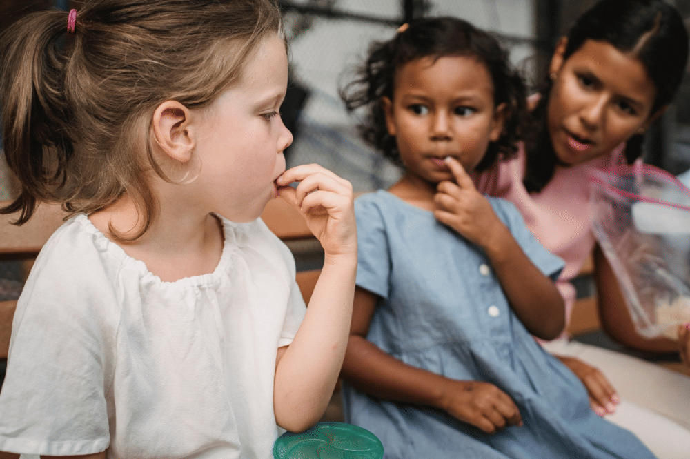 Anak anak sedang makan snack bersama