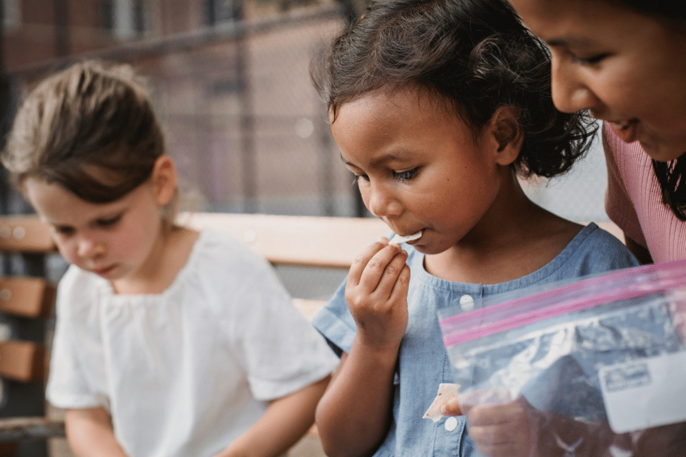 Anak anak sedang makan snack bersama