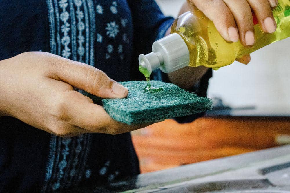 Sabun cuci piring dan air hangat untuk menghilangkan jamur di tas sekolah anak